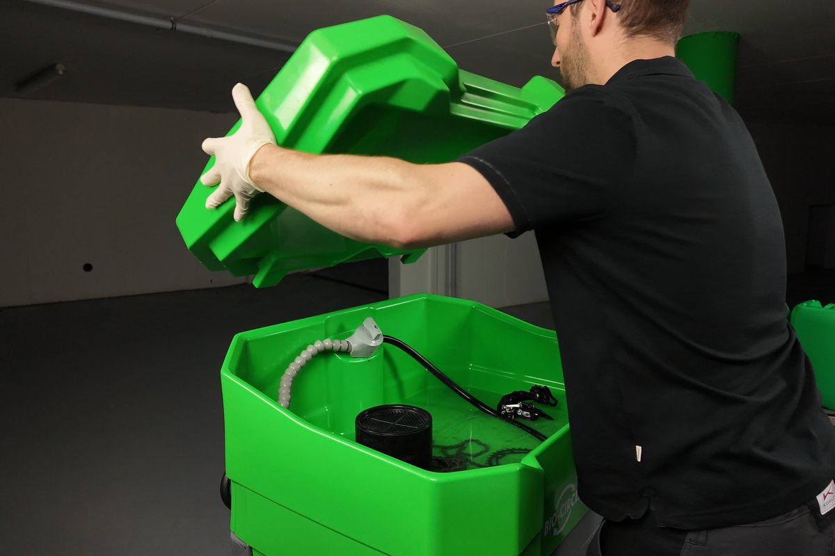 Een Bio-Circle technieker sluit de GT Compact, jerrycans erachter